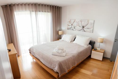 a bedroom with a bed with a teddy bear on it at Sun Island Apartments in Funchal