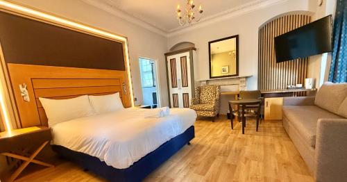 a hotel room with a bed and a living room at The Elder Guest House in Epsom