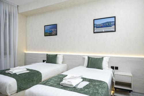 two beds in a hotel room with towels on them at Marmaris Saray hotel NEW in Tashkent