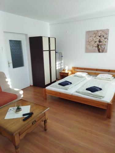 a bedroom with a large bed and a coffee table at Kuckó Apartman in Sátoraljaújhely