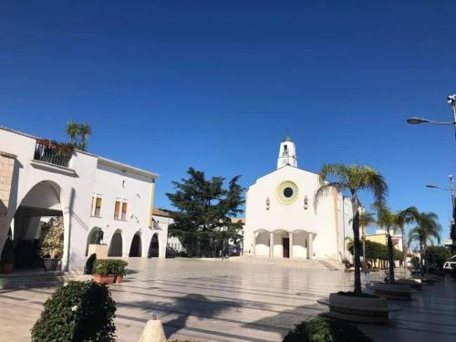 a white church with palm trees in front of it at Graziosa in Policoro