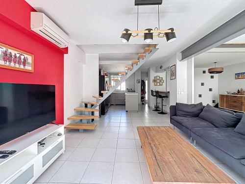 - un salon avec un mur rouge et un canapé dans l'établissement La Villa Palladio, Calme et Détente, à Montpellier