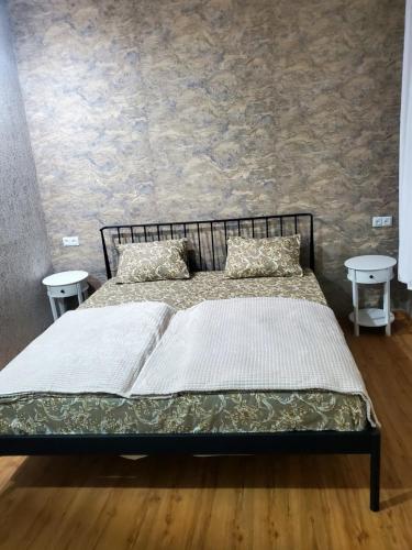 a bed in a room with two tables at Central House in Kutaisi
