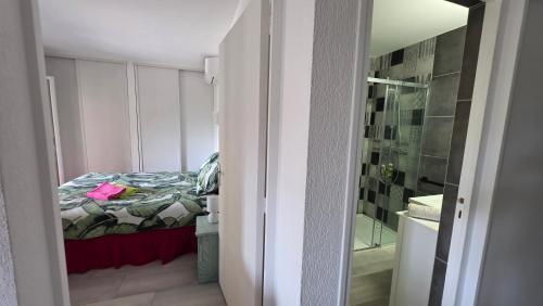 une petite chambre avec un lit et une douche dans l'établissement Entire ground floor in beautiful villa, à Saint-Raphaël