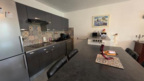 une cuisine avec une table et un réfrigérateur dans l'établissement Entire ground floor in beautiful villa, à Saint-Raphaël