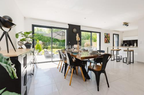 une cuisine et une salle à manger avec une table et des chaises dans l'établissement La Villa Pop Steel - maison avec 4 chambres, à Orgères