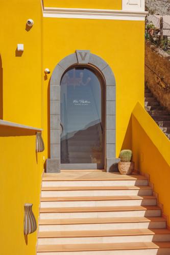 an entrance to a yellow building with stairs at Five Positano in Positano
