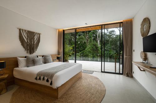 a bedroom with a large bed and a large window at Villa Red Wine by BaliSuperHost in Ubud