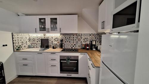 une cuisine avec des armoires blanches et un réfrigérateur blanc dans l'établissement Jolie maison près du port, à La Seyne-sur-Mer