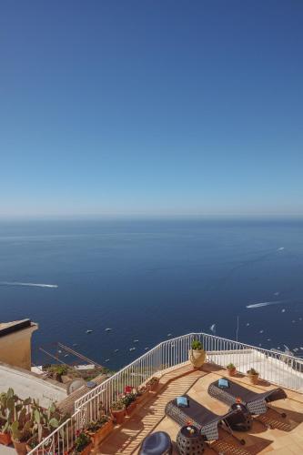 a balcony with chairs and the ocean in the background at Five Positano in Positano