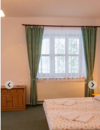 a bedroom with a bed and a window at penzión ARTUR - Partizánske in Otilia