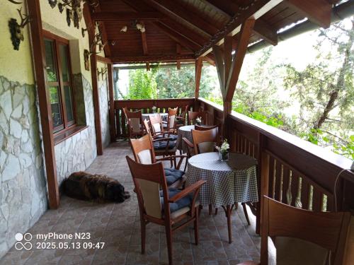 a balcony with tables and chairs and a dog laying on the floor at penzión ARTUR - Partizánske in Otilia