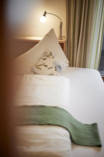 a bedroom with a bed with a lamp and a pillow at Bio Hotel Stillebach in Sankt Leonhard im Pitztal