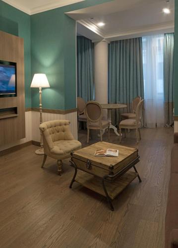 a waiting room with a table and chairs and a couch at ZENTRUM Hotel in Chişinău