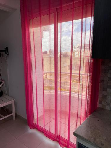 a room with a window with pink curtains at Duplex El mansoura A3 in Kelibia