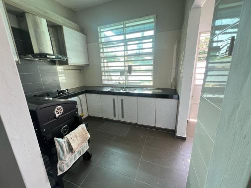 Una cocina con gabinetes blancos y un fregadero. en Homestay Asfa D Village, en Kemasik