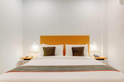 a bedroom with a large white bed with two tables at Collection O Near Kohat Enclave Metro Station in New Delhi