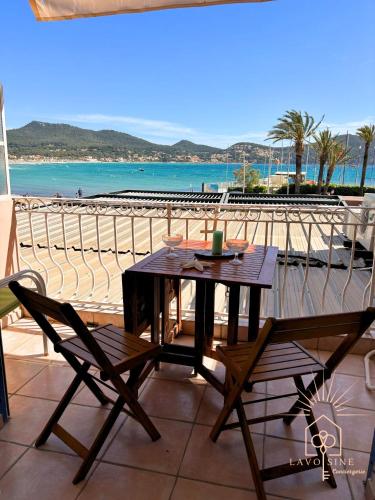 d'une table et de chaises sur un balcon avec une plage. dans l'établissement Les pieds dans l'eau, à Saint-Cyr-sur-Mer