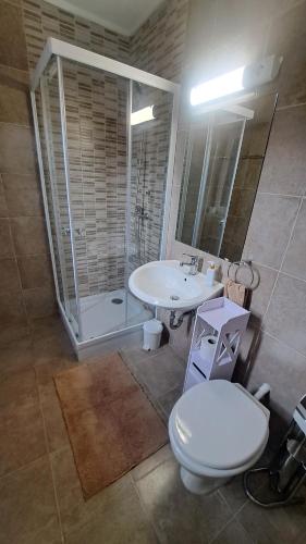 Un baño con inodoro, lavabo y ducha. en IKON Vendégház, en Siófok