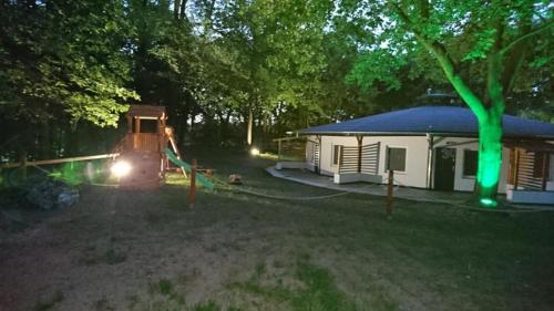 a gazebo with a house with a green light at Ośrodek wypoczynkowy Laguna Skorzęcin in Skorzęcin