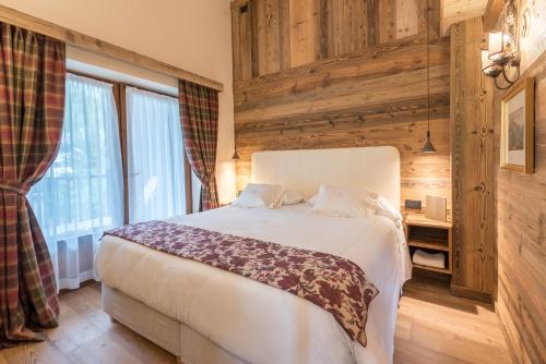 a bedroom with a white bed and a window at Auberge de La Maison in Courmayeur