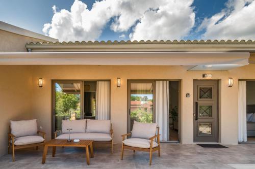 a patio with two chairs and a table at Phos Elegant Residences by Konnect, 400m to the beach in Dassia