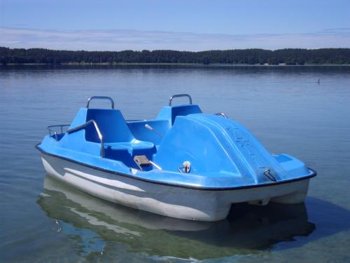 a blue boat sitting in the middle of a lake at Ośrodek Wypoczynkowy "U Kulasa" in Warchały