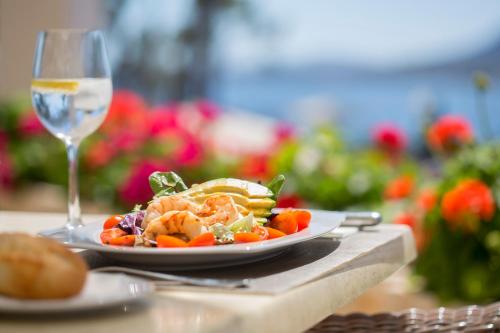 a plate of food and a glass of wine on a table at Hipotels Eurotel Punta Rotja Spa-Golf in Costa des Pins