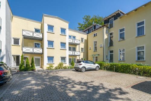 a car parked in a parking lot in front of buildings at Haus Zander in Heringsdorf