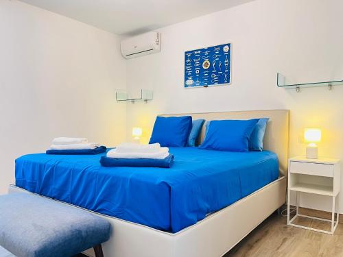 1 Schlafzimmer mit 2 Betten mit blauer Bettwäsche und einem Stuhl in der Unterkunft Villa Nautica Puerto Rico by Alquiler de Súeño in Puerto Rico de Gran Canaria