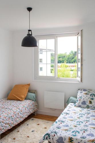 une chambre avec deux lits et une fenêtre dans l'établissement Family home 3 bedrooms with garden, à Biarritz