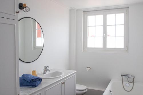 une salle de bain blanche avec un lavabo et un miroir dans l'établissement Family home 3 bedrooms with garden, à Biarritz