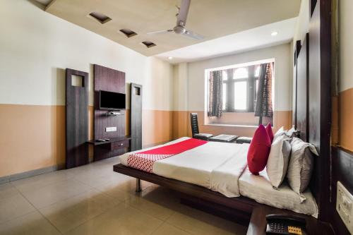 a bedroom with a large bed with red pillows at Hotel O Hadoti Resort in Bhilwara