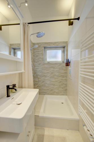 a white bathroom with a sink and a shower at Bungalow - Kinderspielplatz - Garten mit Feuerstelle in Timelkam