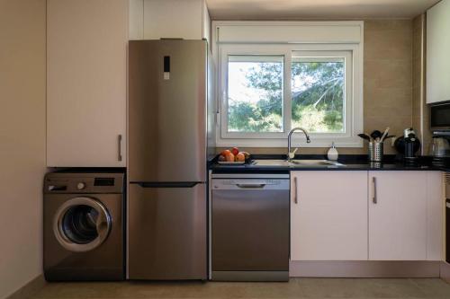 a kitchen with a refrigerator and a washing machine at Hotel Ritual de Terra & SPA Moraira in Moraira