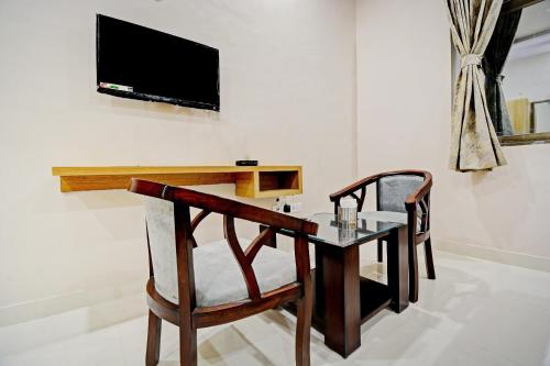 a table and chairs with a television on a wall at Hotel O Hari Krishna Palace in Amer