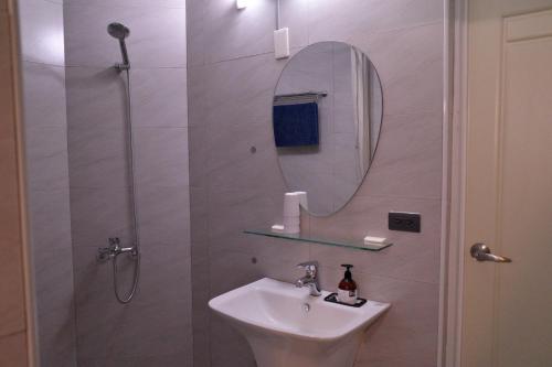 a bathroom with a sink and a shower with a mirror at Meinong Yun Shanju Homestay in Meinong