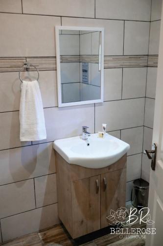 a bathroom with a sink and a mirror at Bellerose Guesthouse in Klerksdorp