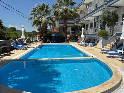 a swimming pool with blue water in front of a building at Family Rooms in Stavros