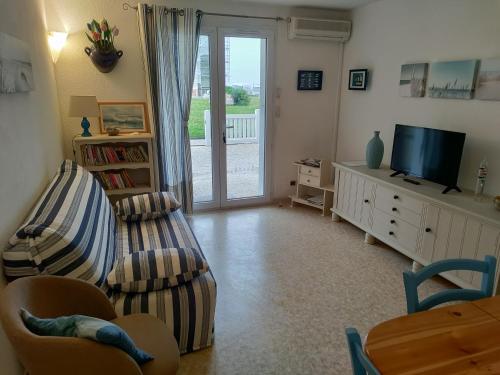 un salon avec un canapé et une télévision dans l'établissement Appartement 2 pièces pour 4 personnes avec vue mer, à Saint-Hilaire-de-Riez