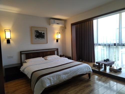 a bedroom with a large bed and a large window at Castle peak yard Inn Free railway st ation pick-up by 2 nights English and Spanish reception available in Guilin