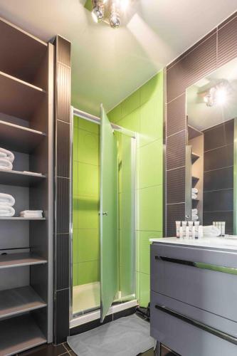 une salle de bain verte avec une douche et un lavabo dans l'établissement Appartement au Touquet - 65m2 proche de la mer et du marché, à Le Touquet-Paris-Plage