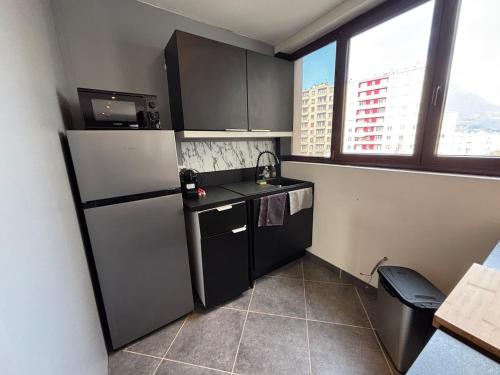 une petite cuisine avec un réfrigérateur et un évier dans l'établissement R'Apparts T2 Au Pied des Alpes, à Grenoble