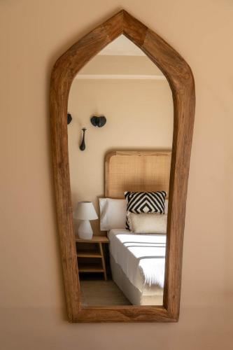 a mirror reflecting a bed in a bedroom at Hotel Ritual de Terra & SPA Moraira in Moraira