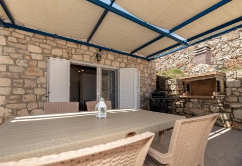 a table with chairs and a bottle of water on a patio at Mikro Nisi Studios & Apartments in Agios Nikolaos