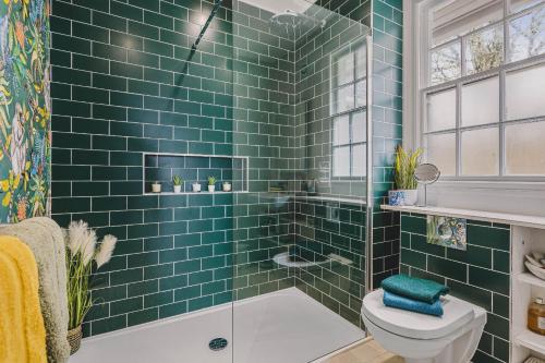 a green tiled bathroom with a toilet and a shower at Little Redlap - Delightful views near Dartmouth in Dartmouth