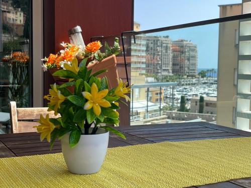 a vase of flowers sitting on a table on a balcony at Monaco Monte-Carlo door step - Luxury Apartment - 2 Bedrooms 2 Bathrooms - Superb Modern Fully Equipped in Saint-Antoine