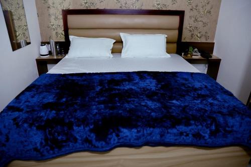 a bed with a blue blanket on top of it at awesome family homestay in Agra