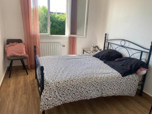 une chambre avec un lit, une chaise et une fenêtre dans l'établissement Maison parc clos 15mn du circuit proche centre, à La Celle-sous-Gouzon