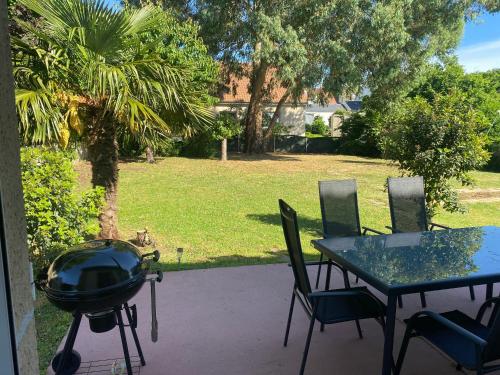d'une terrasse avec un grill, une table et des chaises. dans l'établissement Maison parc clos 15mn du circuit proche centre, à La Celle-sous-Gouzon